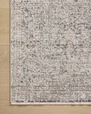 Textured gray patterned area rug on wooden floor.
